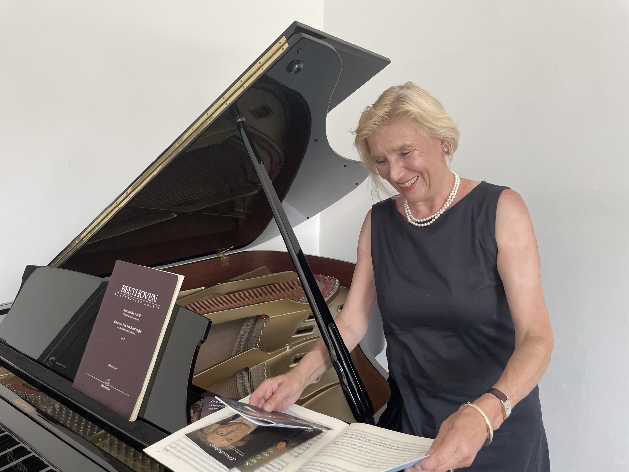 Musikmanagerin Marlies Wagner vor einem Klavierflügel mit Beethovennoten in der Hand.