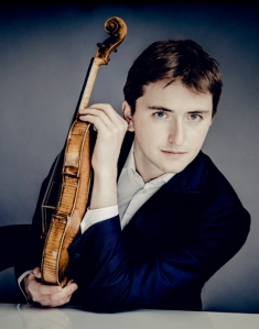 Portaitfoto des Konzertmeister Brieuc Vourch mit einer Violine/Geige in der Hand, zum daneben stehenden Text.